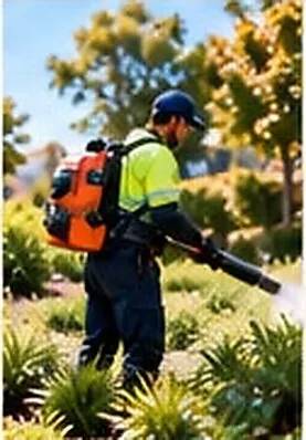 Groundskeeper using a leaf blower in a landscaped garden