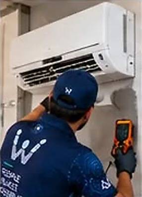 Technician servicing a wall-mounted air conditioner