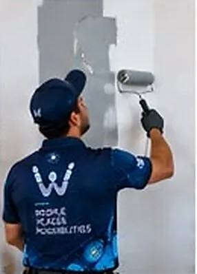 Painter rolling fresh paint onto an interior wall